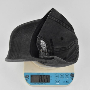 Detailweergave van donkergrijze vintage honkbalpet met gewicht van 86,9g op een weegschaal