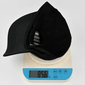 Detailed view of lightweight black baseball cap weighing 85.6g on a digital scale