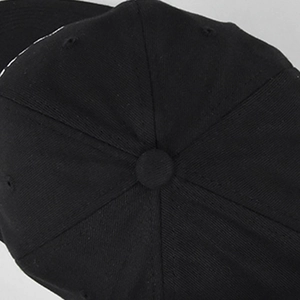 Dettaglio superiore del cappellino da baseball nero con cuciture a sei pannelli e bottone