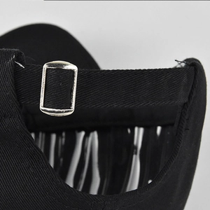 Close-up of black cotton baseball cap with adjustable metal buckle and smooth stitching