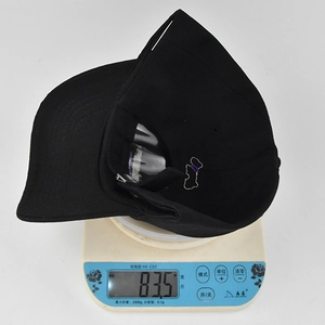Lightweight black baseball cap with LOVE embroidery weighing 83.5 grams on scale
