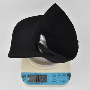 Dettaglio di un cappellino da baseball nero ricamato leggero del peso di 82,2 g sulla bilancia