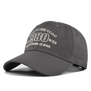 Close-up of vintage 1980 embroidery and white stitching on dark grey baseball cap
