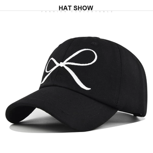 Gros plan de la broderie nœud blanche et de la texture du tissu sur casquette noire