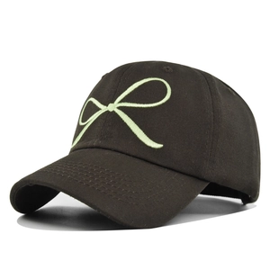 Gros plan détaillé de la broderie nœud vert clair sur une casquette en toile marron foncé