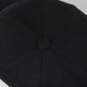 Detail view of the six-panel structure and top button on a black cotton baseball cap