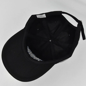 Internal view of black cotton baseball cap showing adjustable strap and sweatband