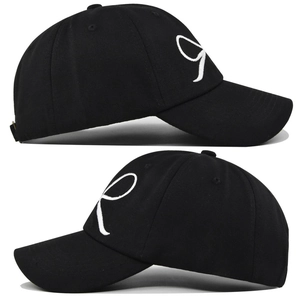 Détail macro de la lettre R brodée en 3D blanc sur une casquette en coton noir de qualité