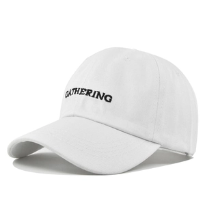 Detailed view of black GATHERING embroidery on a white cotton baseball cap