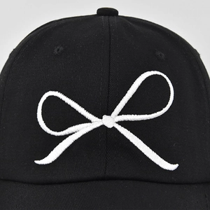 Casquette de baseball en coton noir avec broderie nœud blanc sur fond gris clair
