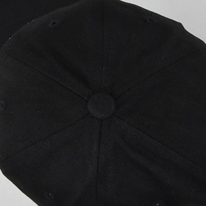 Detailed top view of a black baseball cap featuring six-panel construction and twill texture