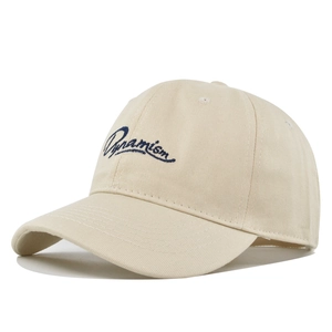 Détail de la broderie Dynamism bleu marine sur le tissu en coton de la casquette beige