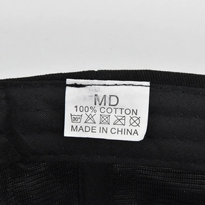 Macro shot showing 100% cotton material label and stitching on black baseball cap