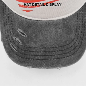 Close-up of distressed brim on washed grey baseball hat with frayed hole details