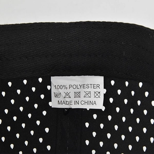 Detail view of mesh hip-hop cap featuring 100% polyester wash label and fabric texture