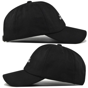 Close-up detail of white letter embroidery on a black cotton twill baseball cap