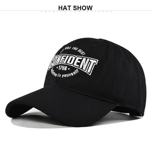 Detailed close-up of white embroidered CONFIDENT text on a black cotton baseball cap