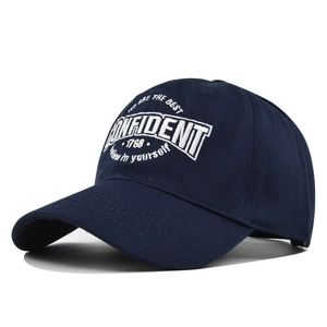 Detailed close-up of white 3D embroidery on a navy blue cotton twill baseball cap