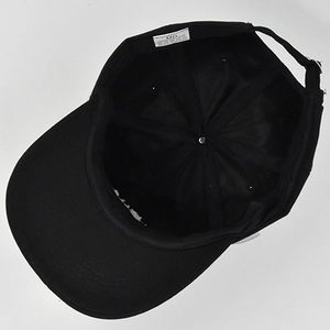 Detail of the black cotton baseball cap interior showing six-panel stitching and adjustable strap