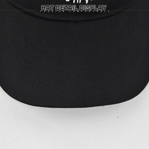 Macro detail showing multi-row stitching on the brim of the black twill baseball cap