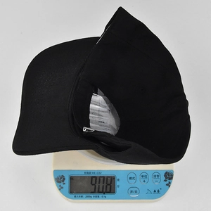 Detailed view showing a black cotton baseball cap weighing 90.8g on a digital scale