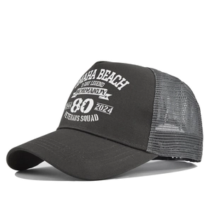 Close-up of dark grey trucker cap featuring white screen-printed Normandy veteran graphics