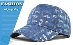 Detailed close-up of holographic QUEEN print on blue washed denim baseball cap