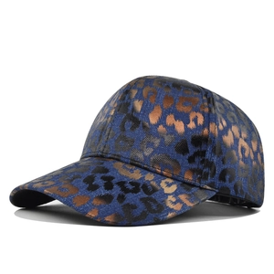 Close-up of vintage washed denim baseball cap with brown leopard print and metallic texture