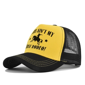 Detail of yellow trucker hat with black mesh and rodeo rider graphic print