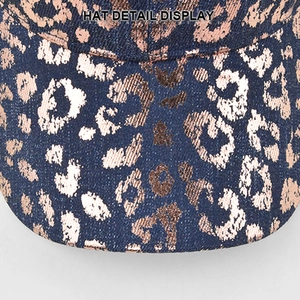 Detail display of vintage blue denim baseball cap with metallic leopard print pattern