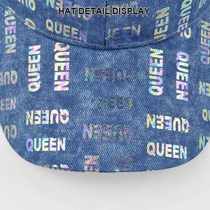 Detail view of denim cap featuring holographic QUEEN print and precision stitching