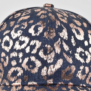 Macro detail of dark blue denim baseball cap with rose gold metallic leopard print texture