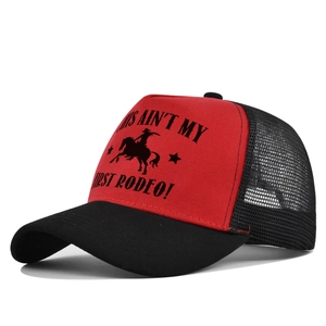 Detail of red and black trucker hat with mesh back and rodeo slogan print