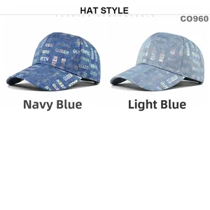 Detail view of navy and light blue denim baseball caps with holographic QUEEN print