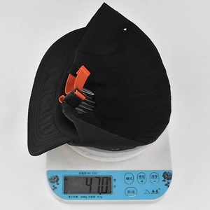 Dettaglio del cappellino hip-hop nero che pesa 47g su una bilancia per design leggero