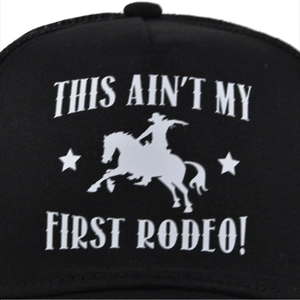 Close-up of silk-screened cowboy rodeo graphic on black mesh snapback baseball cap