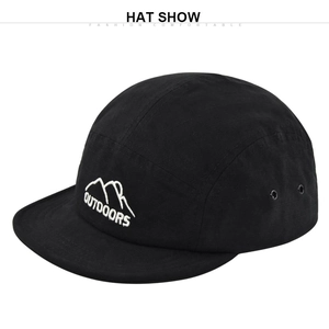 Detail of black cotton camper hat showing white outdoors mountain embroidery and metal eyelet