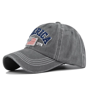 Dettaglio del ricamo America 1776 e toppa bandiera USA su berretto da baseball grigio lavato
