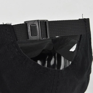 Close-up of the adjustable buckle and nylon strap on a black hip-hop baseball cap