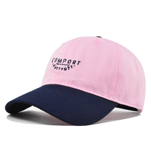 Close-up of the delicate navy blue COMFORT embroidery on pink cotton twill baseball cap