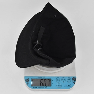 Detailed view of the black hip-hop cap on a scale showing a lightweight of 60.7g