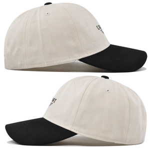 Detail of two-tone cotton baseball cap showing side embroidery and fabric texture