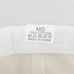 Detail of internal wash care label showing 100% cotton fabric and MD size on baseball cap