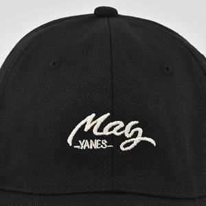 Détail de la broderie blanche Mag YANES sur casquette de baseball en coton noir