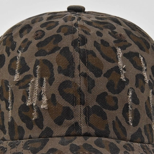 Detailed view of leopard print baseball cap with vintage distressed ripped holes on fabric