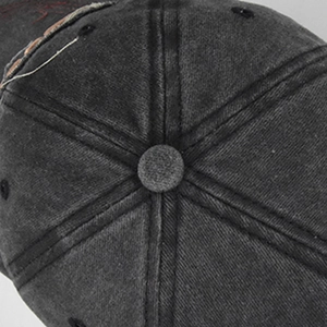 Makroaufnahme des oberen Knopfdetails einer verwaschenen Denim-Baseballkappe im Retro-Look