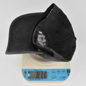 Makroansicht der gewaschenen Denim-Baseballkappe mit Gewichtsanzeige von 87,1g auf Waage