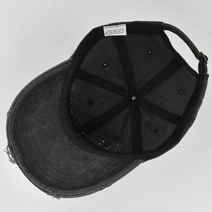 Detail view of the distressed cotton baseball cap showing internal labels and metal buckle