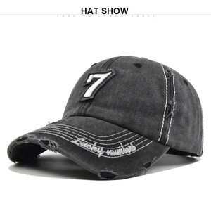 Detail of vintage washed baseball cap featuring number 7 patch and distressed brim embroidery