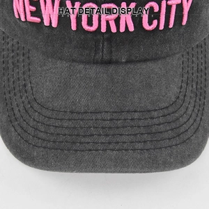 Detail of 3D pink NEW YORK embroidery on dark gray washed denim baseball cap surface